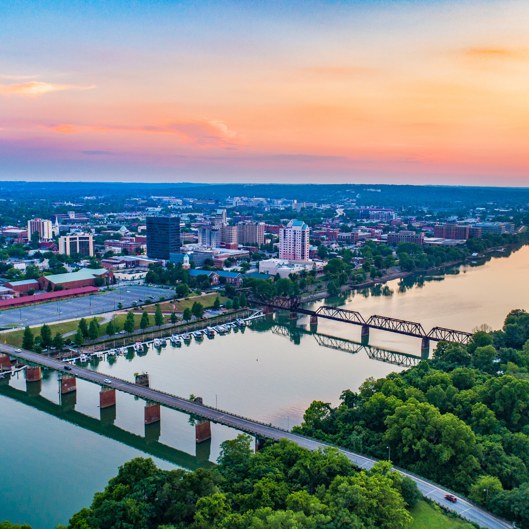 Aerial view of Downtown Augusta showcasing the Savannah River and city skyline at dusk.