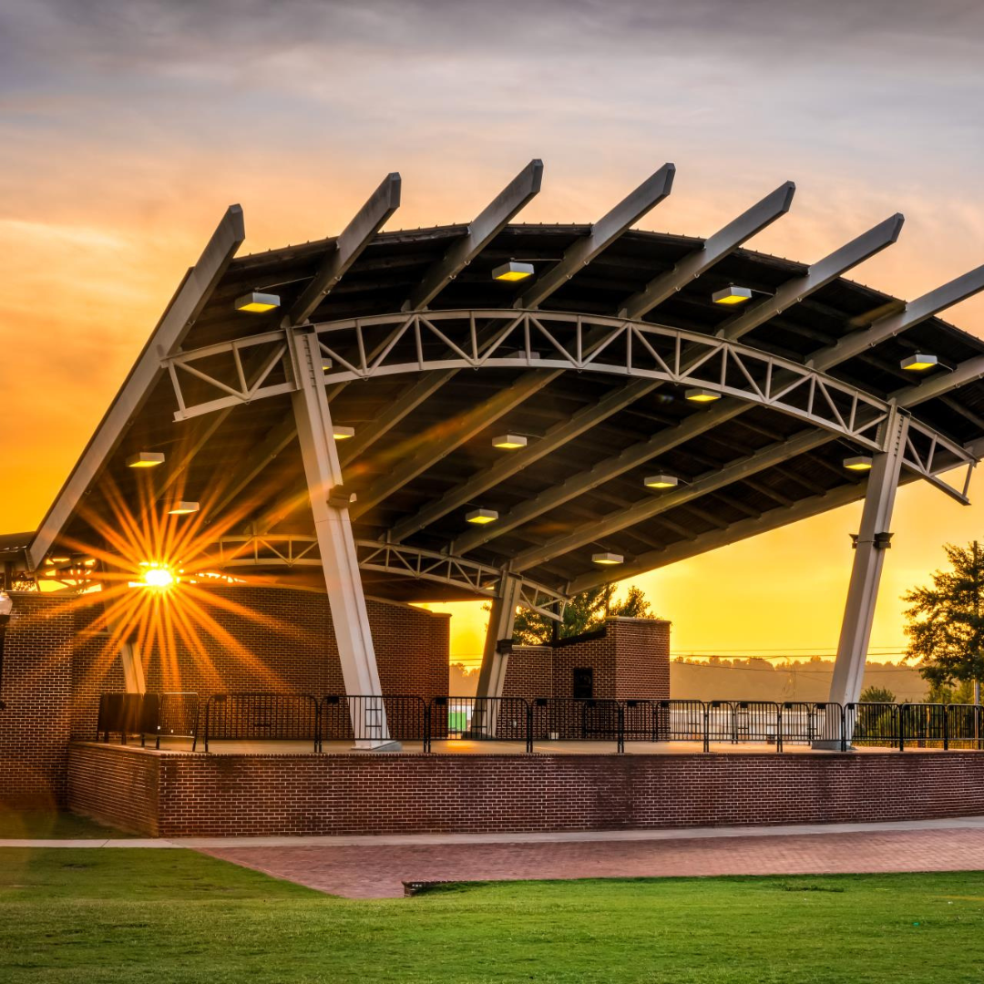 Sunset over the Amphitheater at Evans Towne Center Park with vibrant sky colors and audience seating in view